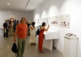 Asistentes observan la exposición 'Las Cuatro Plumas'.