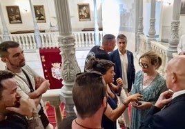 Concejales hablan con los trabajadores del metal en un receso del pleno junto a la escalera principal del Palacio Consistorial