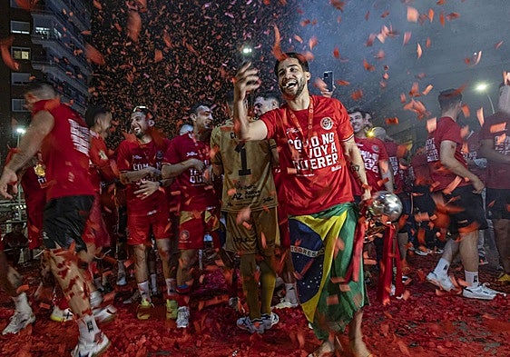 El pívot Waltinho inmortaliza con su teléfono móvil el momento de la fiesta en la Plaza de España, la pasada madrugada, en medio de la lluvia de confeti rojo.