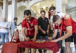 Waltinho, Paulo Roberto, Duda y Mellado firman la bandera de la ciudad, este viernes, con el título de Liga, en la recepción oficial en el Palacio Consistorial.