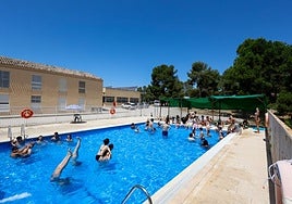 Los jóvenes integrantes de un campamento se refrescan en la piscina del albergue Casa Iglesias, en la sierra de La Culebrina.