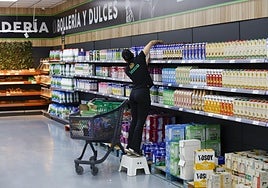 Una empleada de un supermercado en Murcia repone productos en el establecimiento.