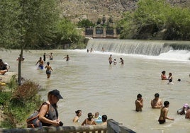 Vecinos y turistas en El Jarral de Abarán, con el tobogán natural al fondo, su principal reclamo.