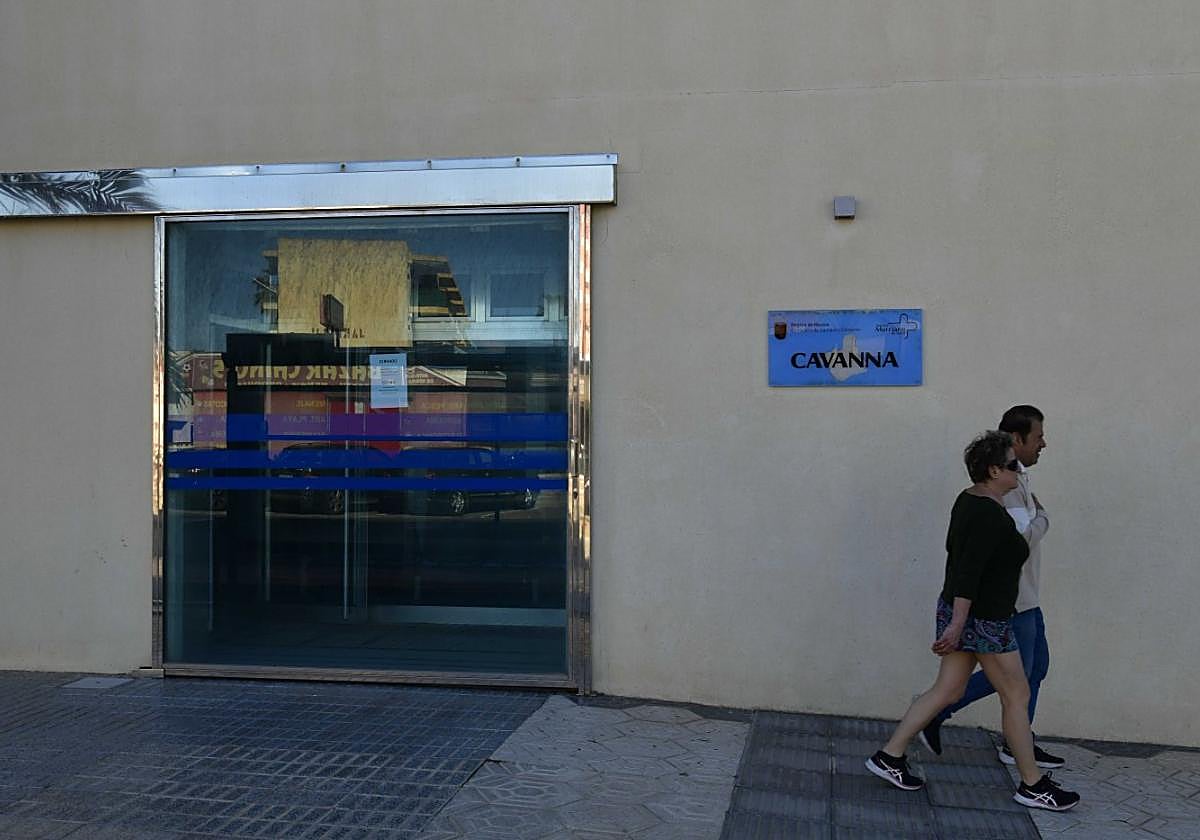 Dos personas caminan frente al consultorio médico de la plaza del Cavanna en La Manga.