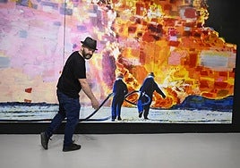 Manuel Pérez posa delante de su obra 'El desafío', expuesta para la muestra 'Llueve fuego' en el Centro Párraga.