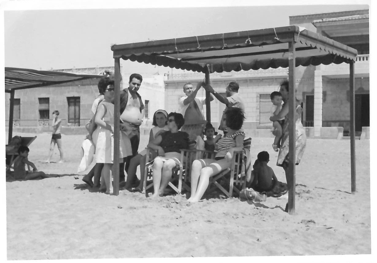 Una familia disfruta de un día de playa en los tradicionales toldos que se montaban en La Isla. La mayoría de las casas ya han desaparecido.