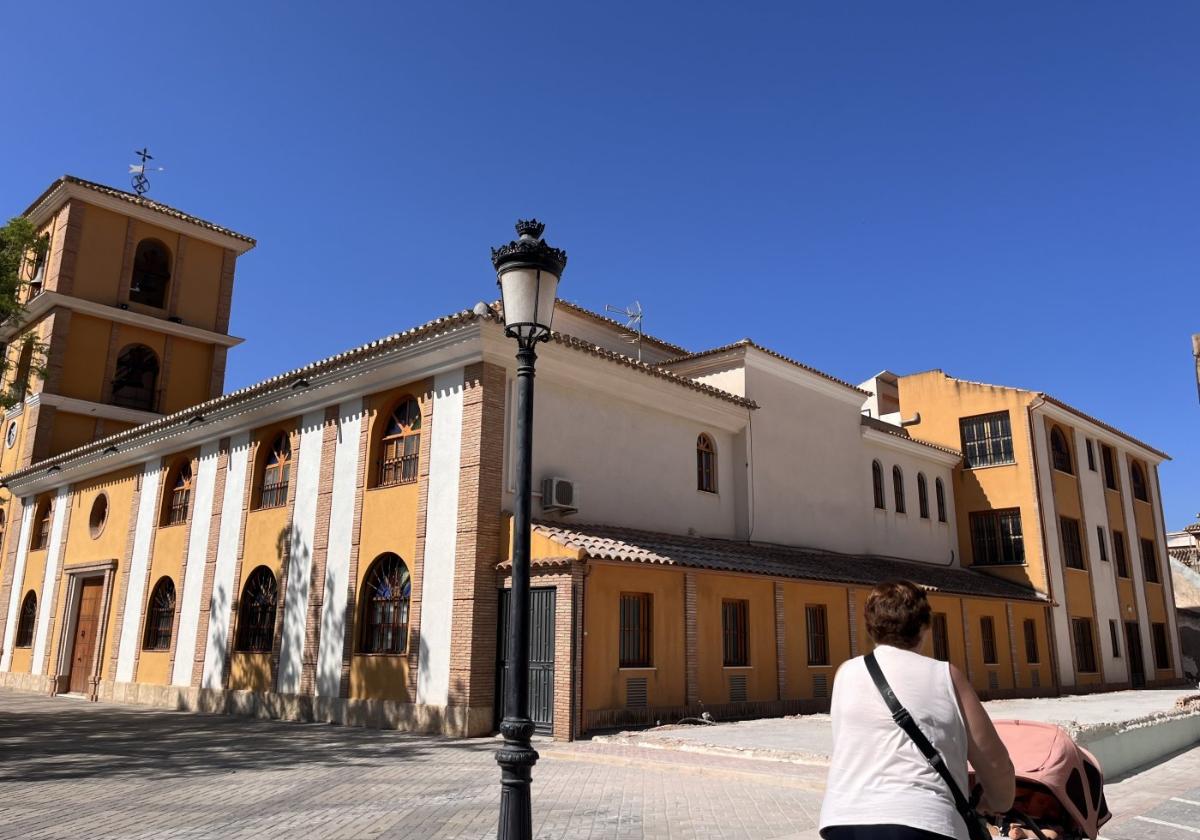 Una mujer pasea al lado de la parte trasera de la iglesia de La Concepción, recién recuperada.