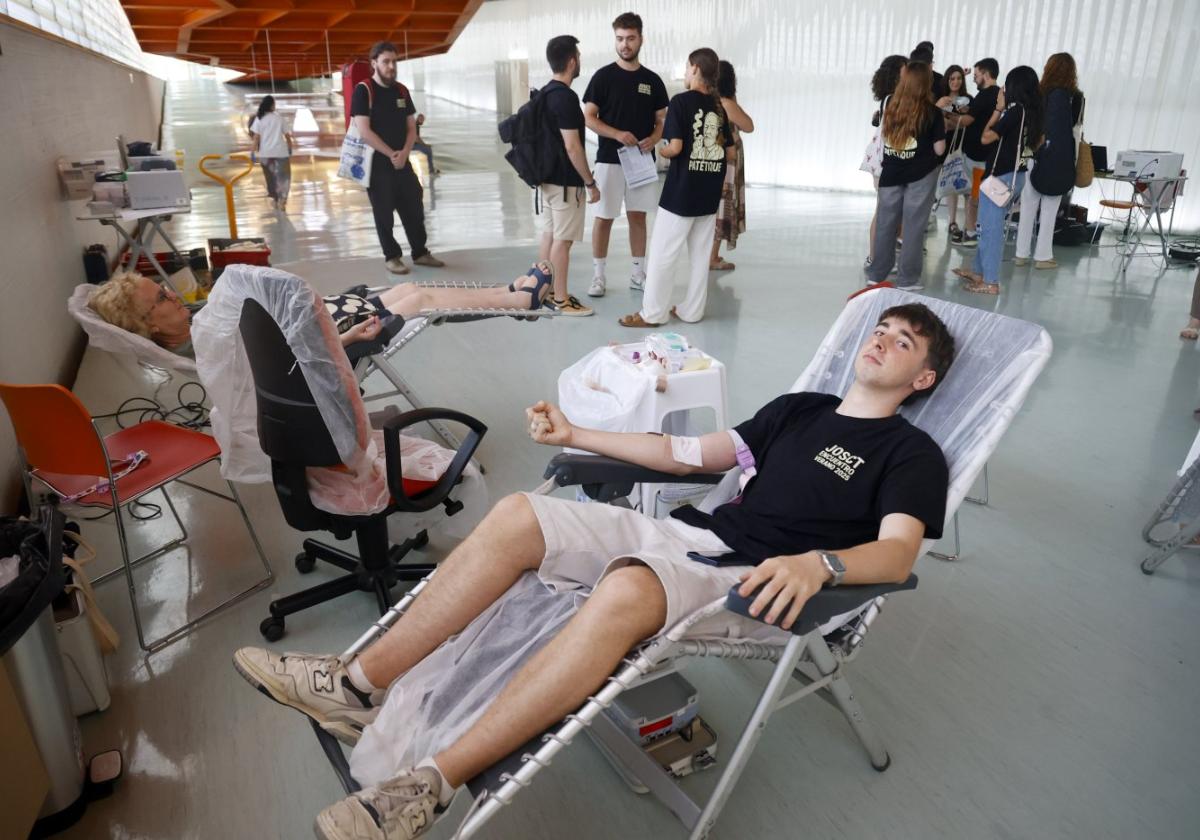 Un joven y una mujer donan sangre durante la jornada celebrada en el auditorio del Batel.