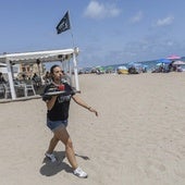 Una camarera camina por la arena de la playa de Levante los 50 metros que separan el quiosco de las hamacas, tal y como exige este año Costas.