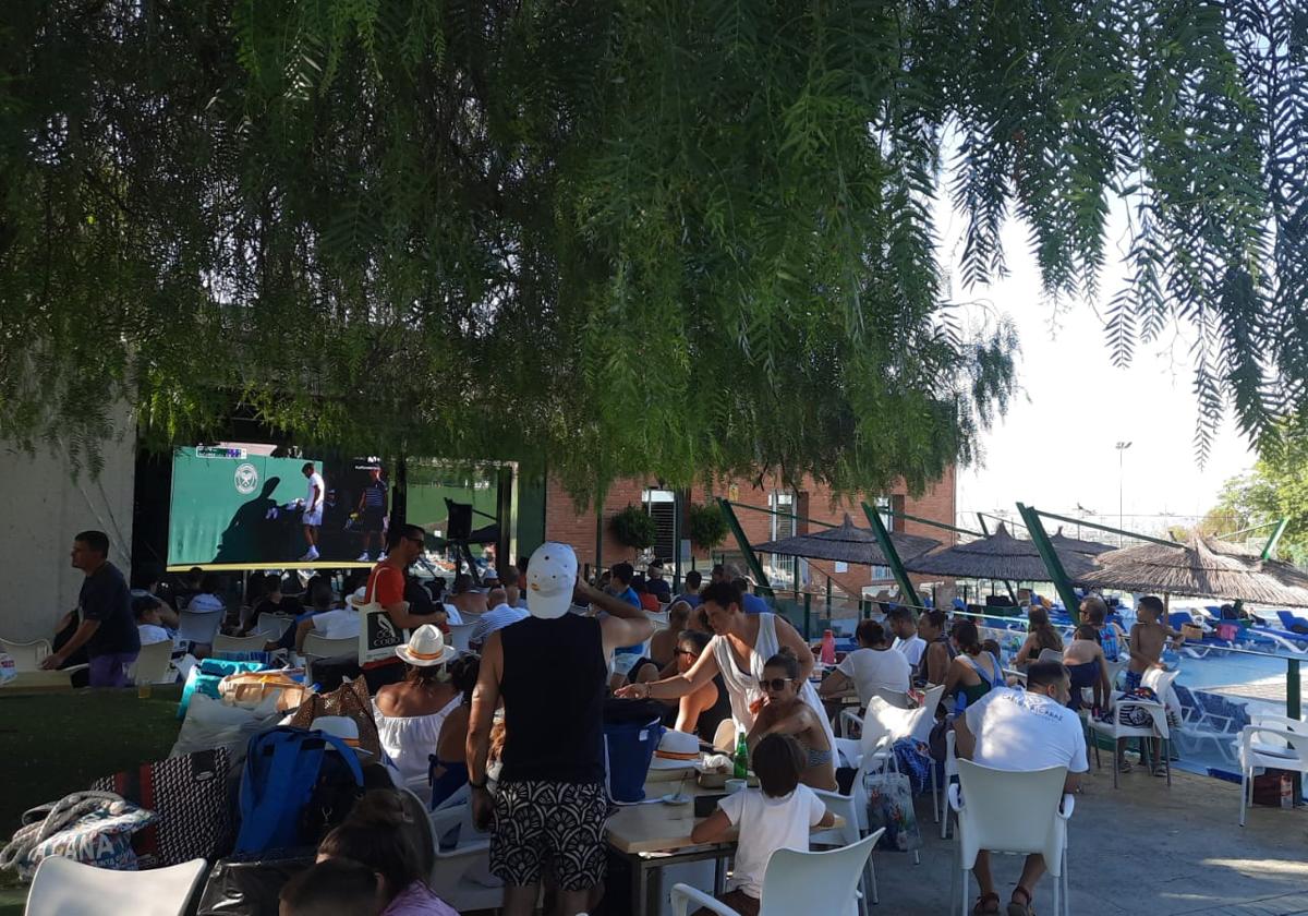 Vecinos de El Palmar se refugian del calor para ver la final de Wimbledon, este domingo.