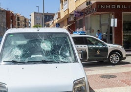 Un coche de la Guardia Civil patrulla por el barrio de San Antonio, en Torre Pacheco, junto a una furgoneta con la luna destrozada.