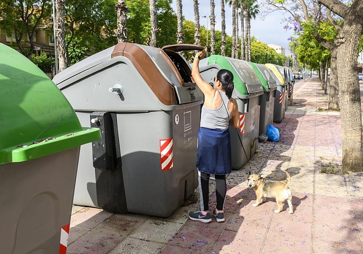 Una mujer deposita su bolsa en el contenedor marrón durante una prueba piloto en Murcia.
