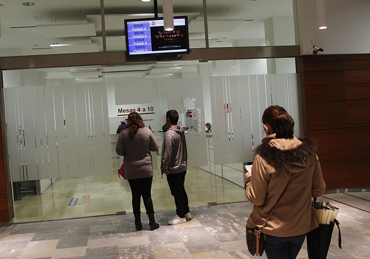 Tres personas aguardan su turno para ser atendidas en las oficinas municipales de San Miguel.