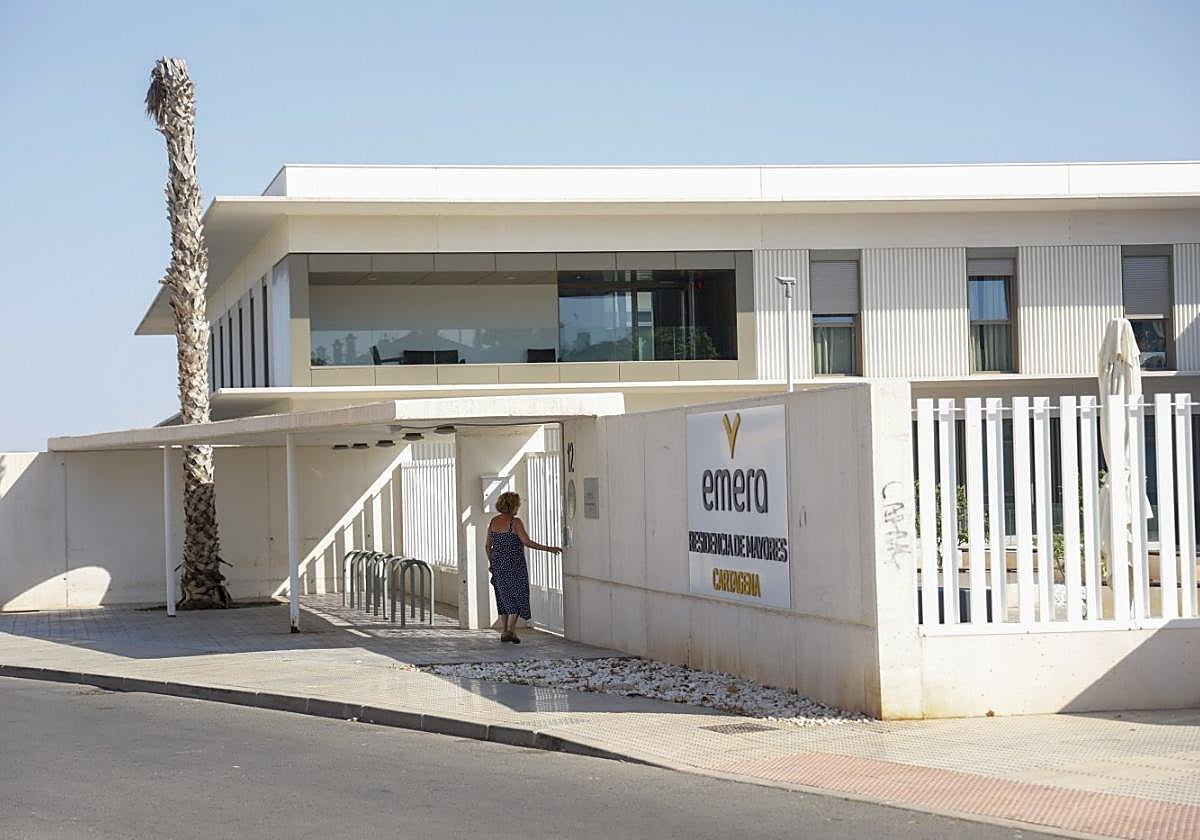 Una persona toca al timbre en la puerta principal de acceso a la residencia.
