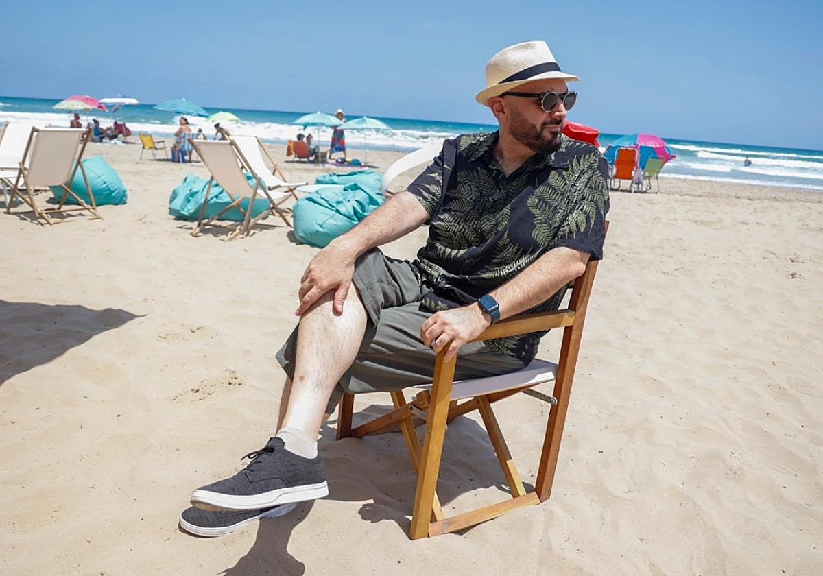 Un urbanita en la arena. Miguel Ángel Hernández, en una playa de La Manga, haciendo un aparte de una comida con amigos.