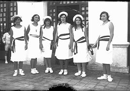 Almuerzo de gala.Jóvenes en la puerta del embarcadero del Real Club de Regatas con la gorra de los tripulantes del navío alemán 'Emden' (1934).