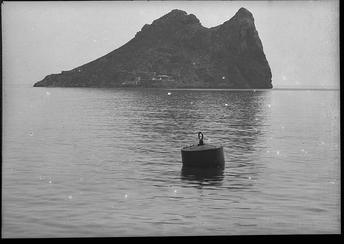 Imagen secundaria 1 - El Hornillo. Bote del buzo, fijando defensas en El Hornillo, según descripción del propio autor (c. 1902). | Isla del Fraile. Panorámica de la isla, con una boya en primer término (c. 1903). | Familia. Hijos de Gillman sentados junto a la orilla en la playa de El Hornillo (1899). 