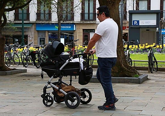 Un hombre pasea con su bebé en una imagen de archivo.