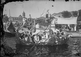 Comitiva. En primer término, embarcación a remo adornada con una figura de Santiago Apóstol y con varias mujeres y niños a bordo (c. 1930).