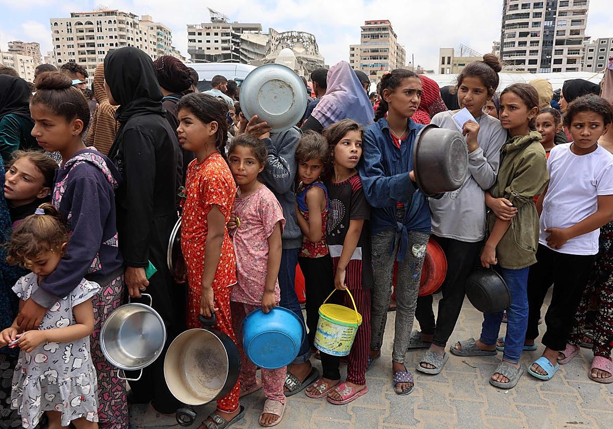 Cola de palestinos, la mayoría niños, para conseguir algo de comida en Gaza.