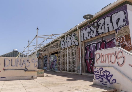 Locales cerrados con pintadas en la parte superior de la galería.