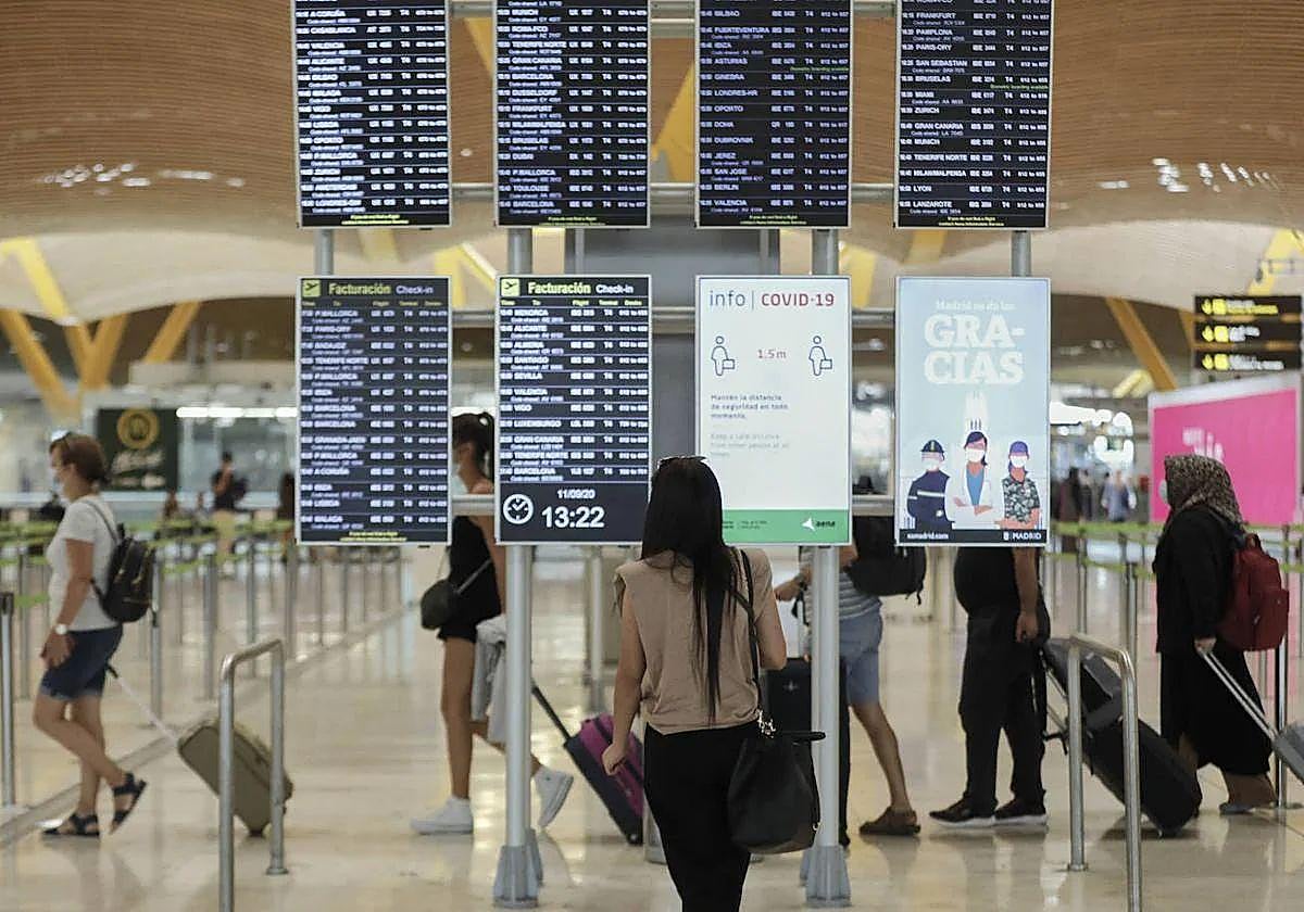 Imagen de archivo de una mujer mirando las pantallas en un aeropuerto.