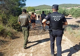 Un agente medioambiental y otro de la Policía Local de Murcia acompañan a los senderistas extraviados este domingo.