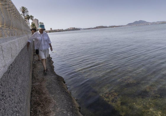 Una mujer residente pasea por el único espacio que queda en la orilla del polígono y por la ocupación de un chalé en La Manga.