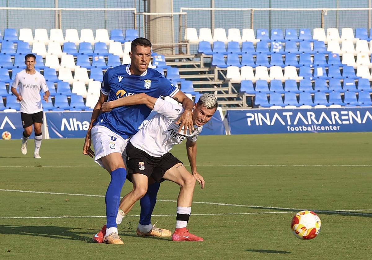 Luismi Redondo, del Cartagena, disputando un balón ante Pelón, futbolista del Melilla, el pasado martes en Pinatar Arena.