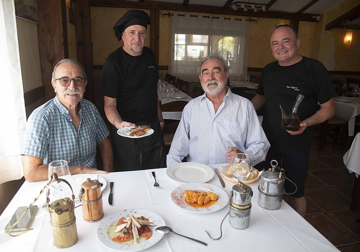 De izquierda a derecha, Vicente Rivas, Tomás Cegarra, jefe de cocina, Pedro Baños y Antonio Cegarra, jefe de sala, durante la comida con cuatro lámparas mineras sobre el mantel de la mesa y el típico porrón Belmonte.