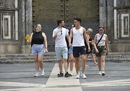 Un grupo de jóvenes se abanica este lunes frente a la Catedral de Murcia.