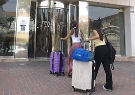 Dos chicas entran cargadas de maletas por la puerta del hotel Los Habaneros, ayer.