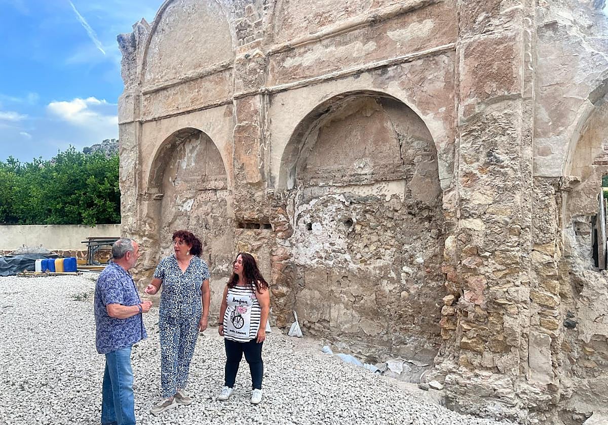La arqueóloga María José Morcillo (d), en la ermita, junto al alcalde y la conservadora Olga Briones (c).
