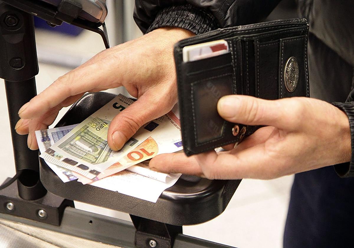 Una persona paga con dinero en efectivo.