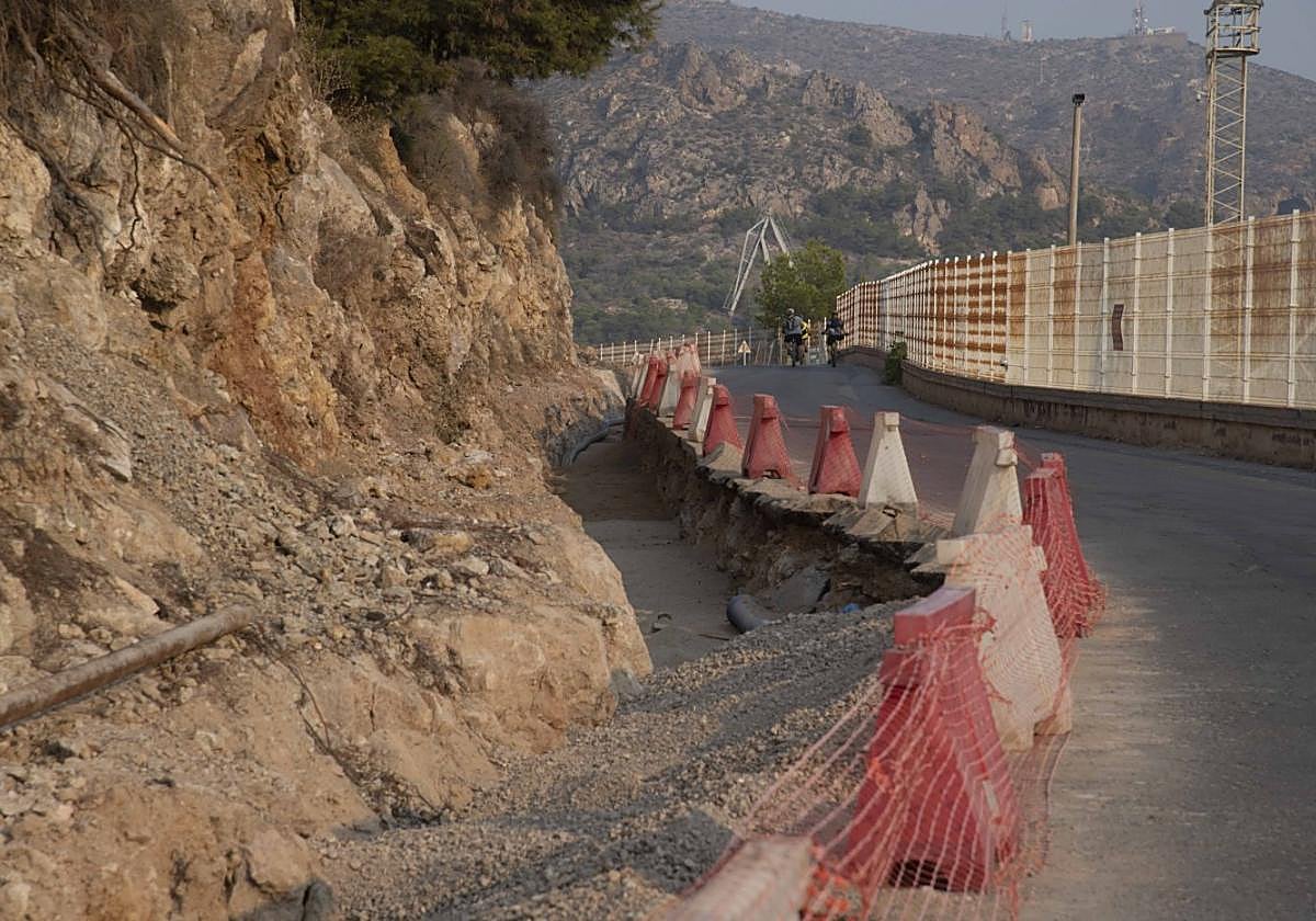 Dos ciclistas pedalean por la carretera del Espalmador a primera hora de la mañana, junto a la zanja abierta por los obreros.