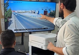 El alcalde, junto a un policía, mira la imagen de una cámara instalada en la carretera hacia el Llano del Beal.