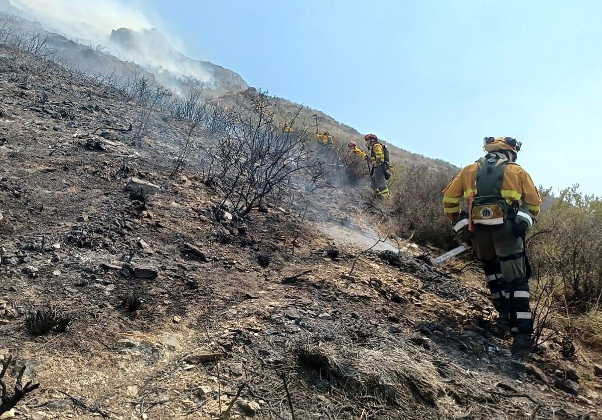 Bomberos refrescan la zona afectada.