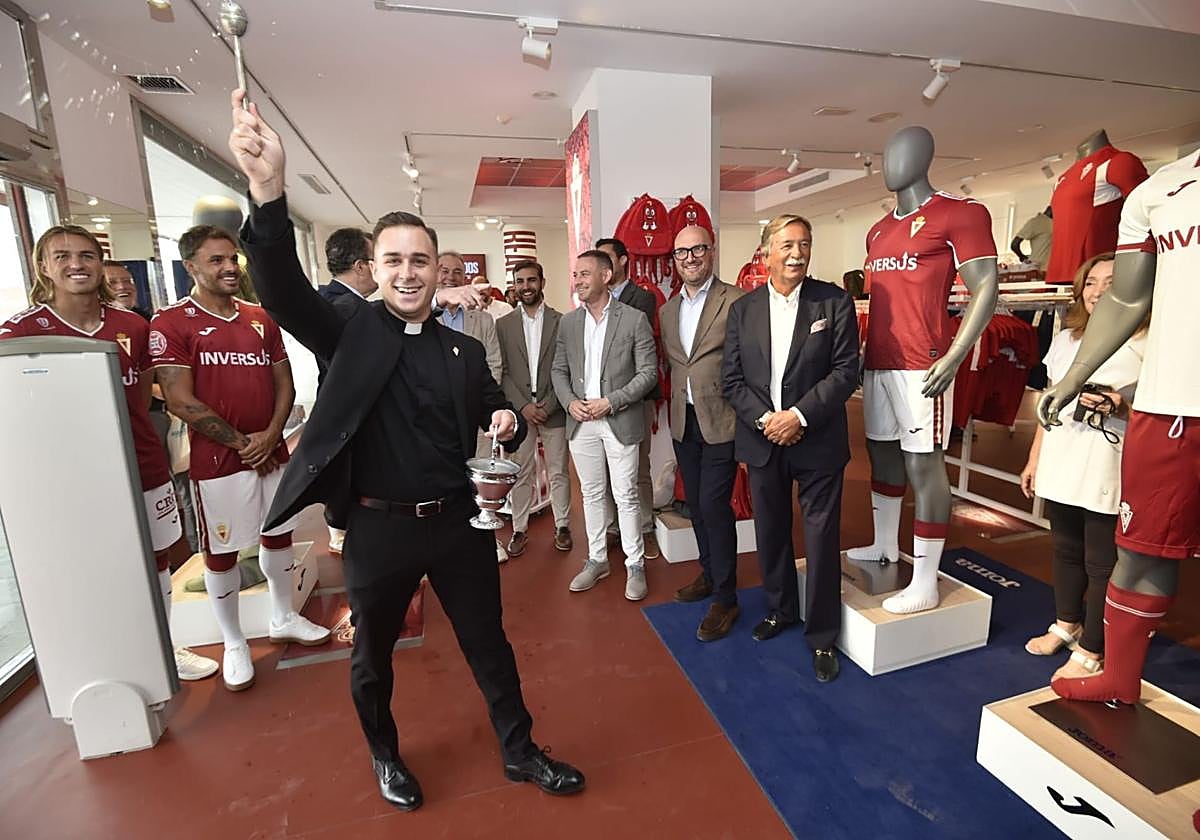 El sacerdote Miguel Tovar bendice la tienda del Real Murcia, este miércoles, durante el acto de inauguración.