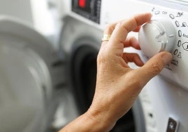 Imagen de archivo de una persona poniendo la lavadora.