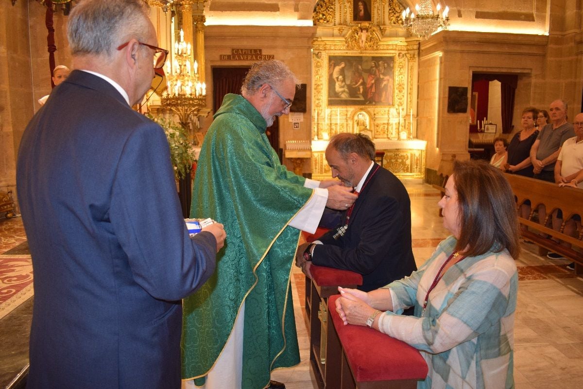 El rector de la basílica, Emilio Sánchez, en el momento de imponer la Cruz de Caravaca a Reinón
