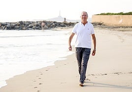 Carmelo Conesa, paseando por una playa de La Manga. Al fondo, el faro de Cabo de Palos.