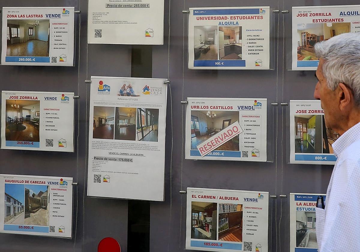 Un hombre mira los anuncios de venta de pisos de una inmobiliaria.