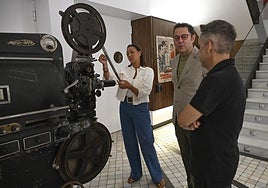La consejera de Cultura observa los proyectores donados por el operador de cabina Miguel García.