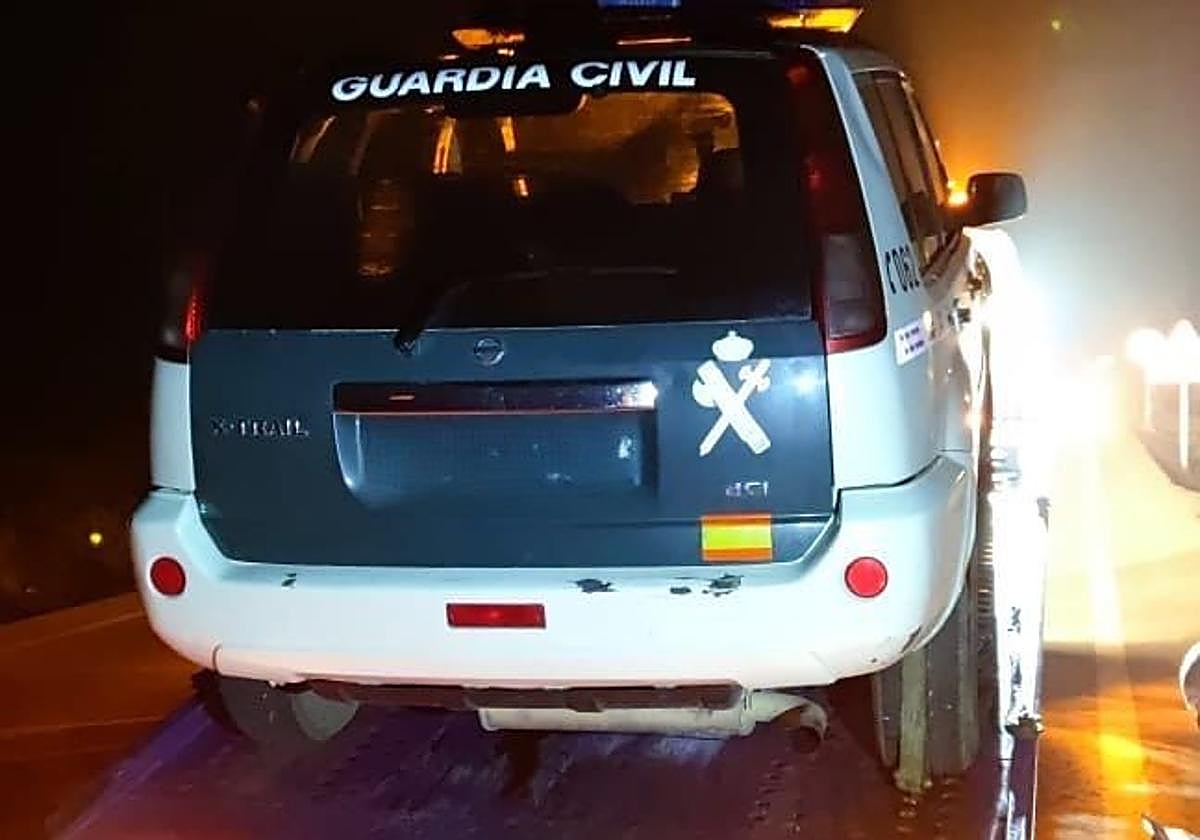 Un vehículo de la Guardia Civil subido a una grúa para su reparación.