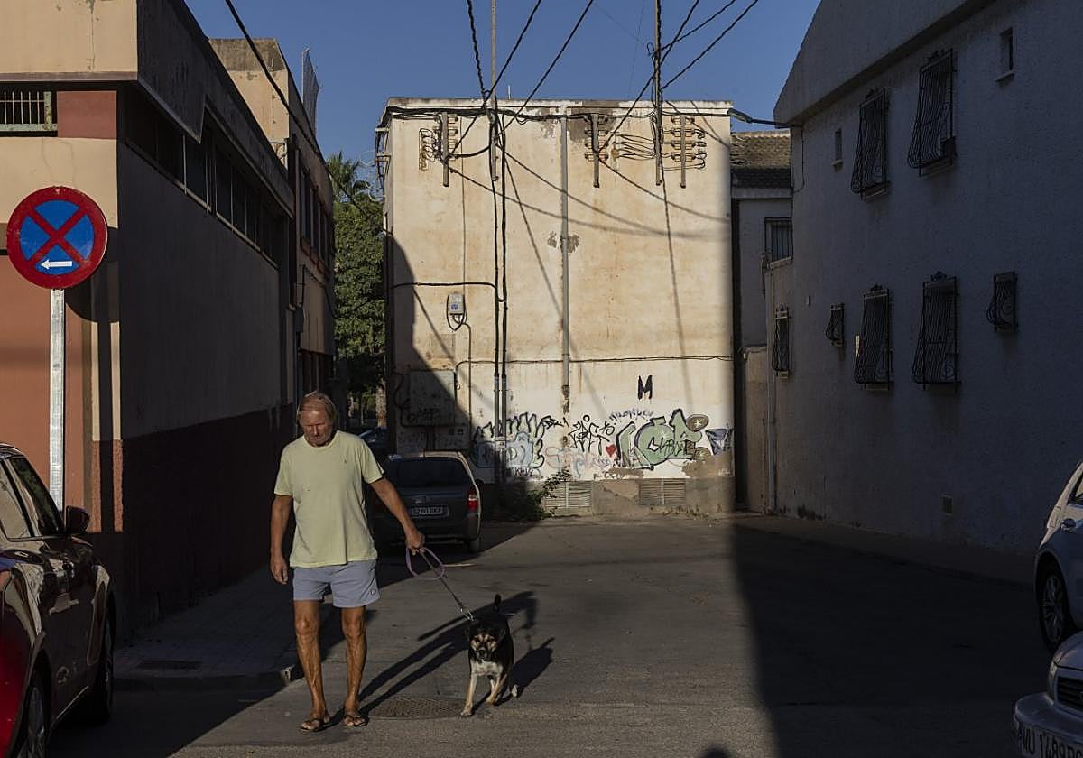 Un vecino paseo a su perro junto al transformador.