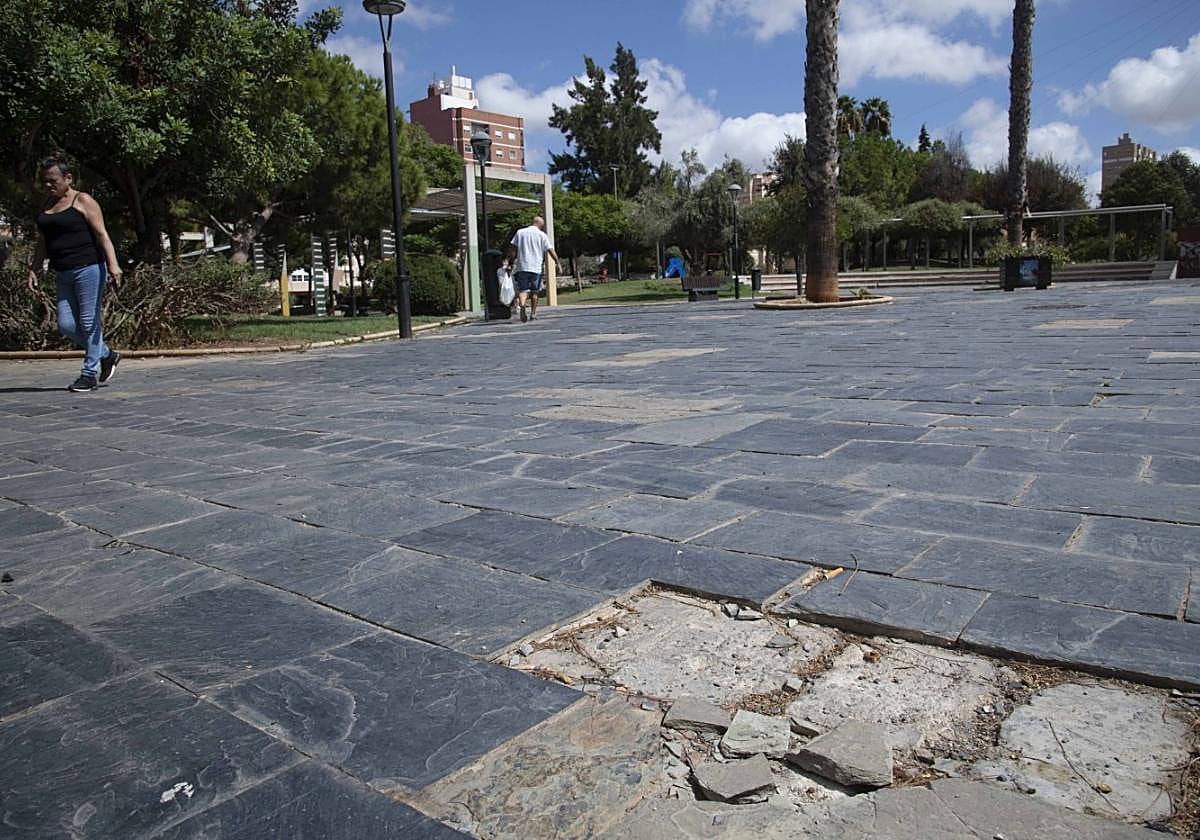Vecinos pasean por el parque de los Juncos, que presenta múltiples desperfectos en el enlosado de la plaza central.