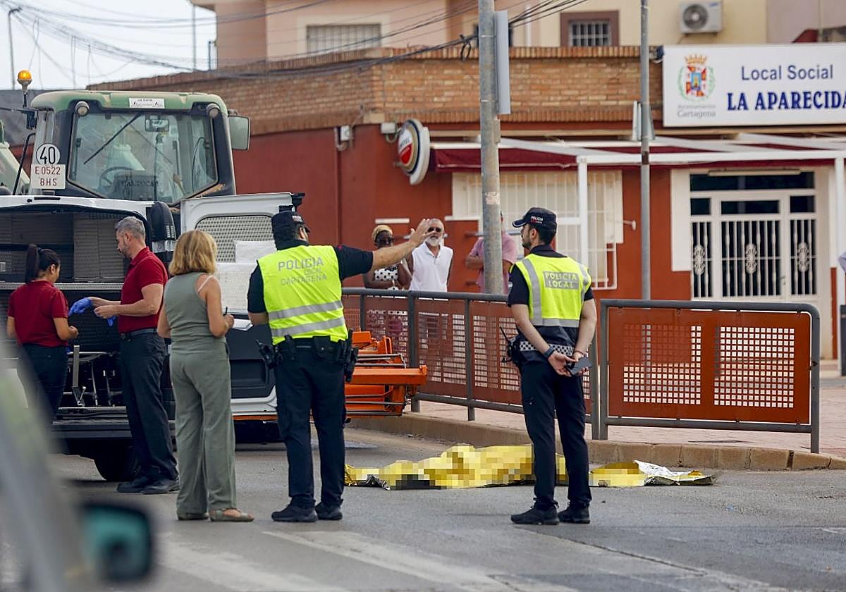 Trabajadores del servicio funerario se disponen a trasladar el cadáver de la mujer.