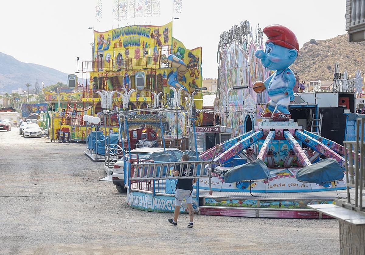 Un feriante da los últimos retoques a las atracciones.
