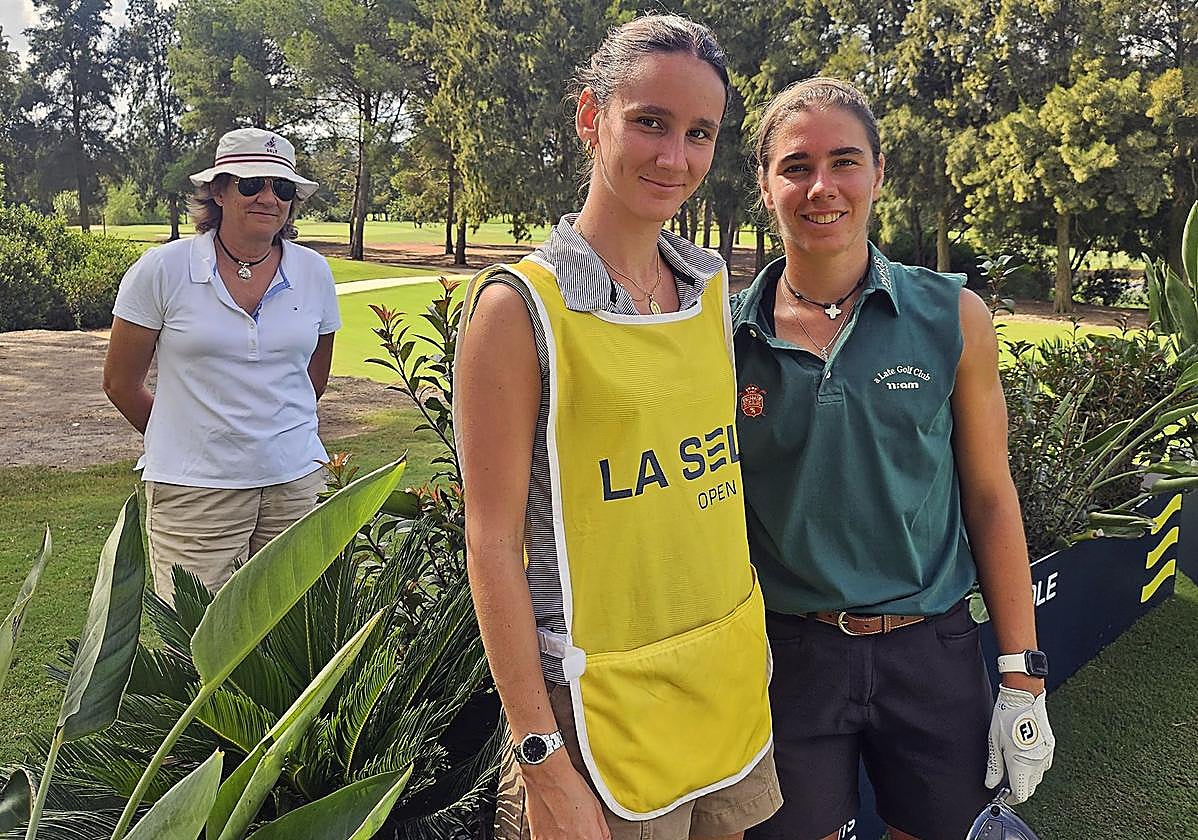 Paz García-Poggio (detrás) siguiendo discretamente a su hija Blanca Fernández, acompañada por su hermana Gabi (i), que le hace de 'caddie' en La Sella Open.