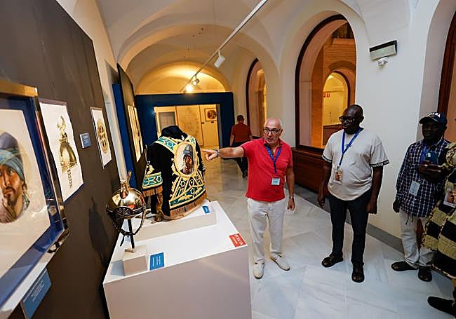Jesús García muestra los bocetos de un bordado y un casco y esas piezas expuestas en la muestra.